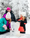 A family sculpting an ice block with sculpting tools