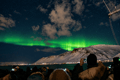 Green and purple Northern Lights stretching across the night sky during a boat tour from Reykjavík.