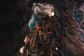 Visitors walking through a lava cave with dramatic volcanic rock formations