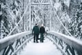 Couple crossing a wooden bridge on a winter hike near Rovaniemi